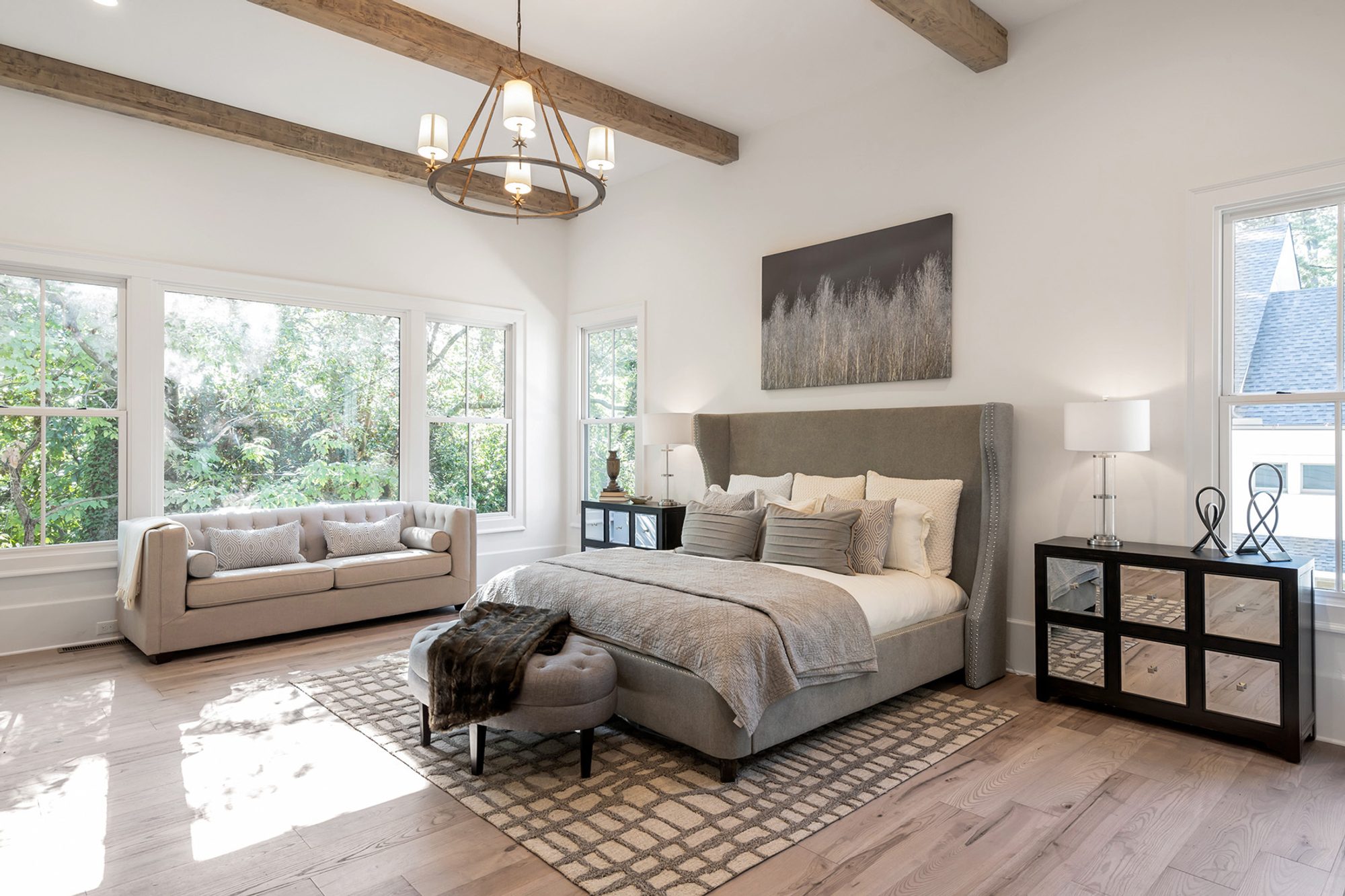 gray and cream master bedroom plush gray headboard area rug dropped wood beams hardwood floors