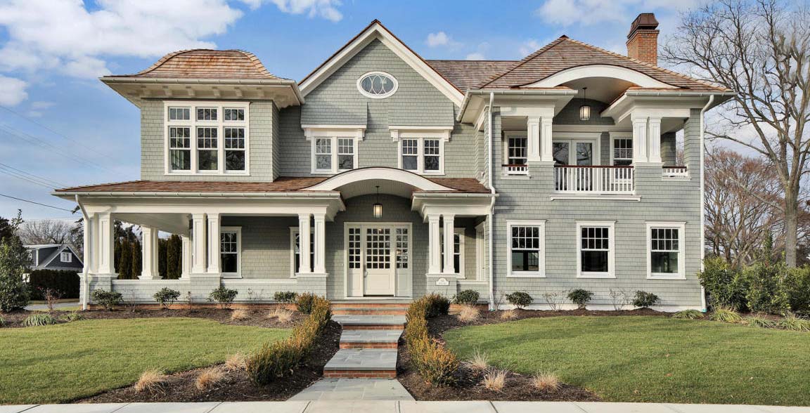 custom home with gray siding and white front door