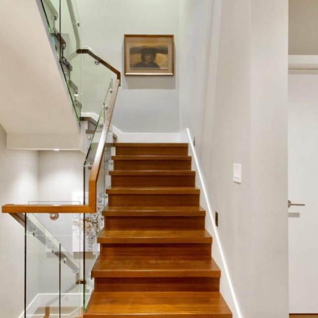 Contemporary stair design, wood treads and risers with modern glass railings and wood hand rail