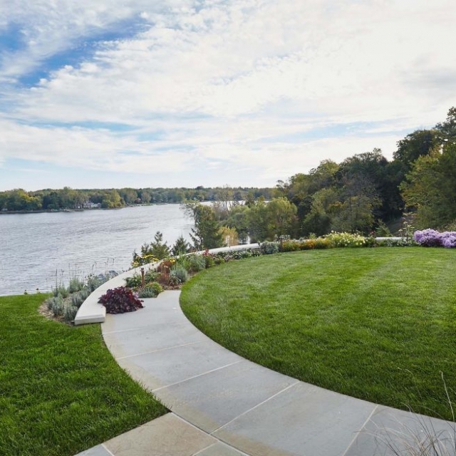 waterfront landscaping round bluestone and concrete patio