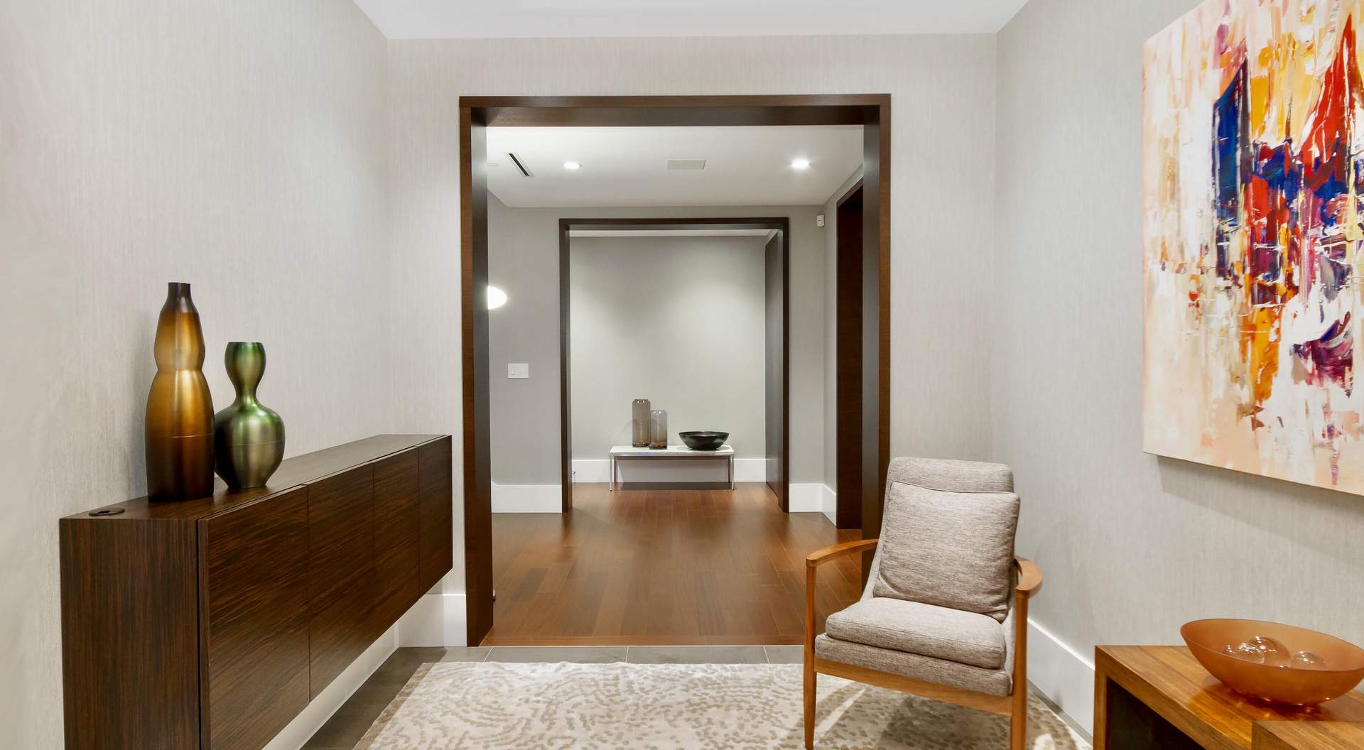 modern entry, floating wood cabinets, gray tile, artwork, wood furniture, modern minimalist wood trim