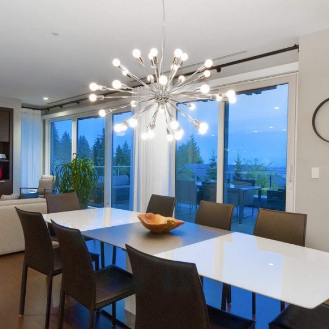 Modern open floor plan, modern chandelier, glass walls, gray walls, white kitchen table