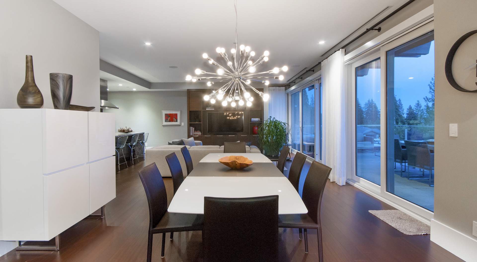 Modern home dining room, modern chandelier, white rectangle dining room table, leather chairs