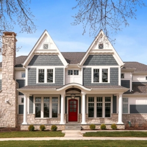 Blue Colored house. Cedar shake siding. Red front door with white trim and columns. Light colored stone veneer. Azek wall paneling.