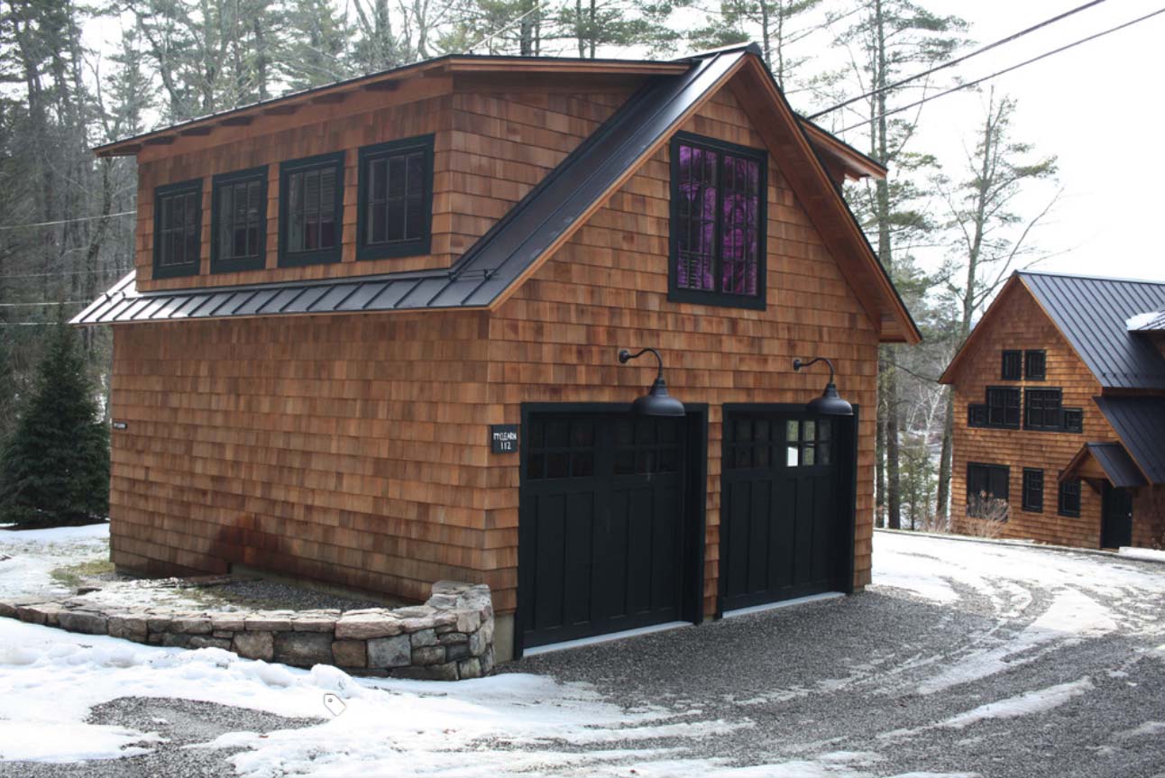 Detached garage design with cedar shake wood siding and black trim. Black garage doors. Black metal roofing.