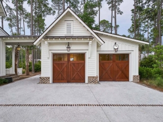 2 Car detached garage design with breezeway. Horizontal white lap siding. White trim. Stained brown wood doors. Architectural details. Red brick base veneer. Metal accent roof. Fancy garage design.