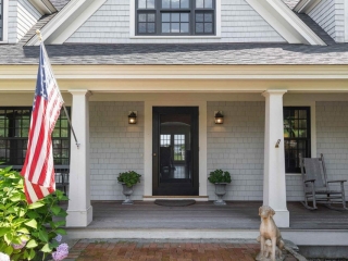 Gray house siding colors with black front door and white trim. White columns. Black framedwindows.