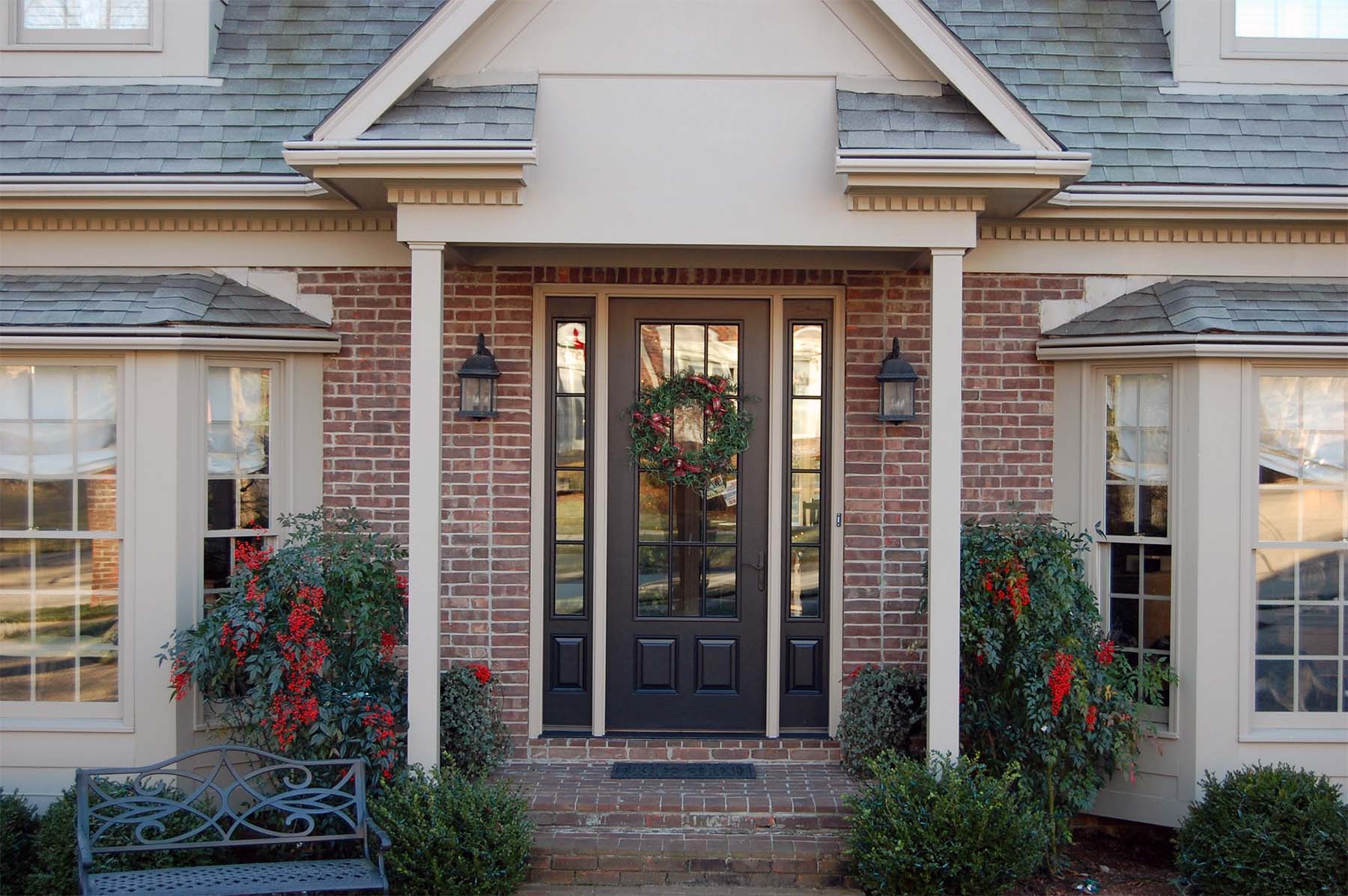 black front door with side transoms tan trim with red brick house