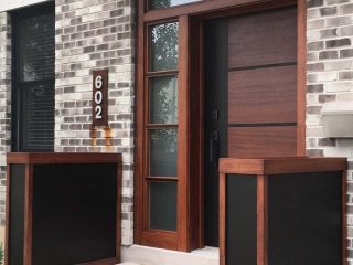 modern wood front door with glass transom brown and black with red brick house