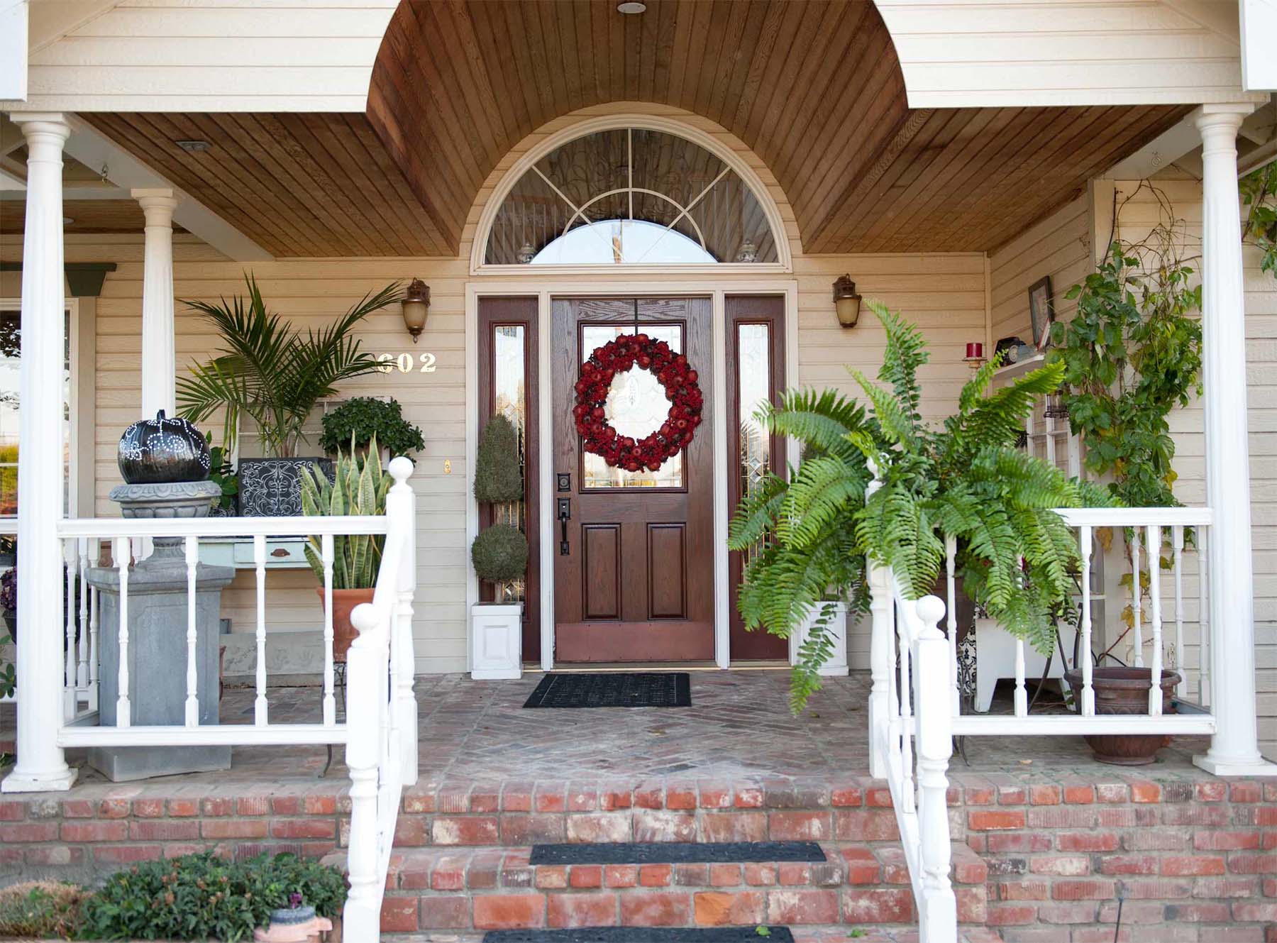stained wood front door with glass transoms wood soffet red brick front porch house