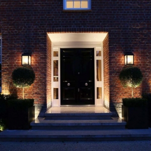 black front door with glass transoms and white trim beautiful landscaping brick house at night