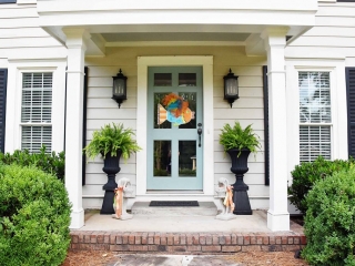 Pale blue front door with glass white trim black shutters red brick front stoop
