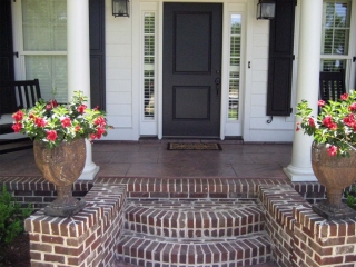 black front door with glass transoms white house with black shutters red brick front steps