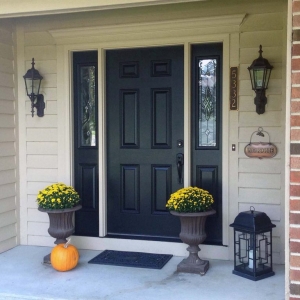 black front door with glass transoms with red brick house concrete front steps yellow porch flowers