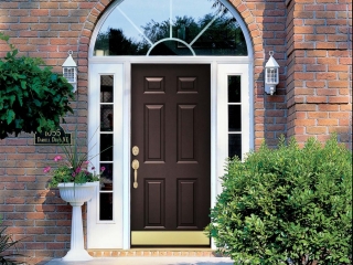 black front door with white trim glass transoms red brick house lots of plants white door lights