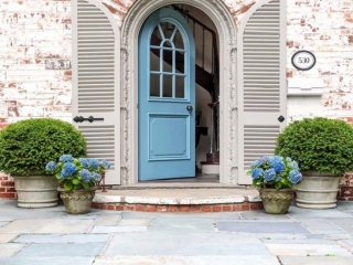 light blue front door with white washed red brick house blue stone patio and porch plants