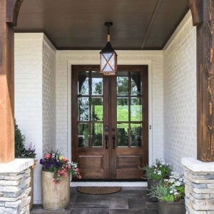 real wood front door with white brick house wood columns stone pillars