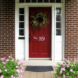 dark red front door with white trim and glass transoms red brick house colorful porch plants