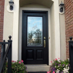black front door with stucco surround gold hardware red brick house black iron railings