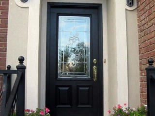 black front door with stucco surround gold hardware red brick house black iron railings