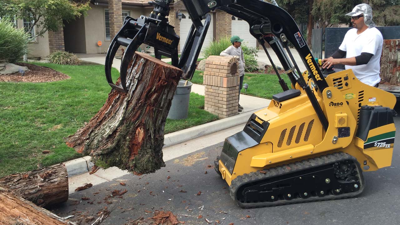 NJ Tree removal Service Picking up tree trunks with a machine