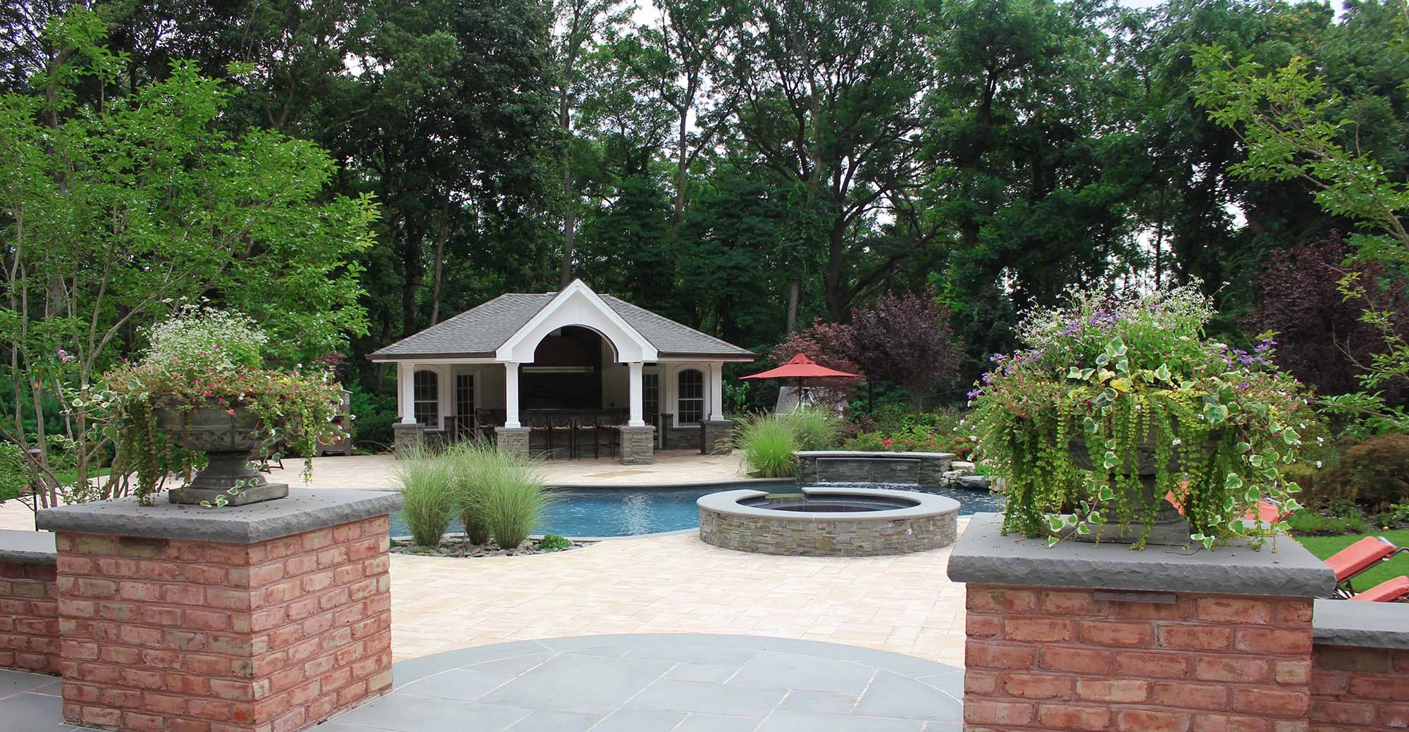 pool house design with huge patio pavers and blue stone brick pillars in ground pool real stone