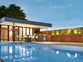 modern flat roof pool house design red brick with wood trim negative edge swimming pool