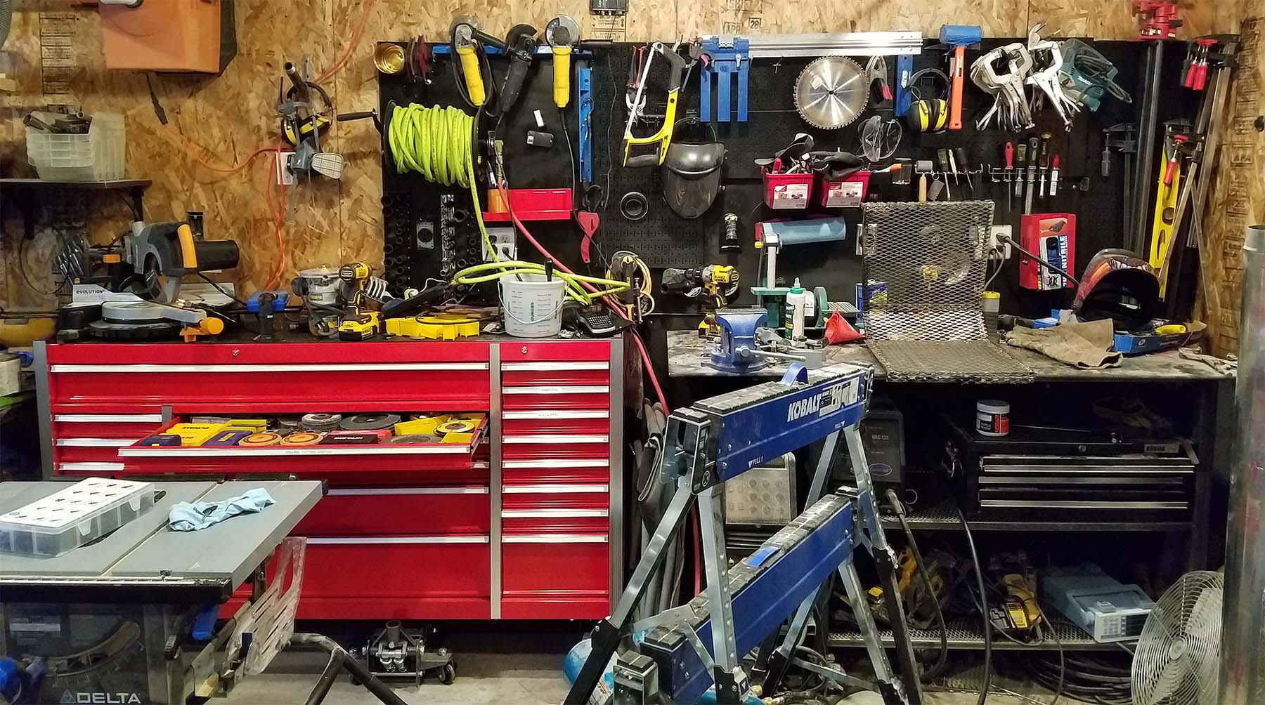work bench full of tools picture with screw guns and a cordless drill