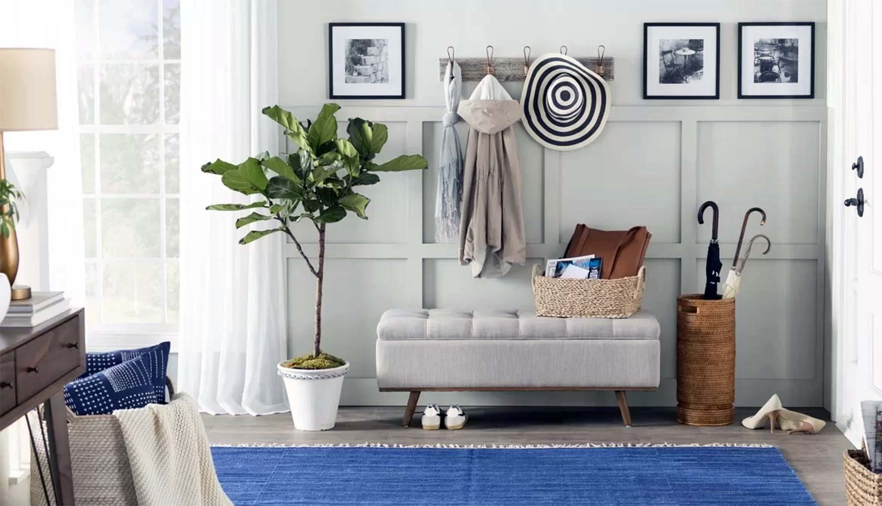 a beautiful foyer with bench seating plants and storage blue area rug wall paneling