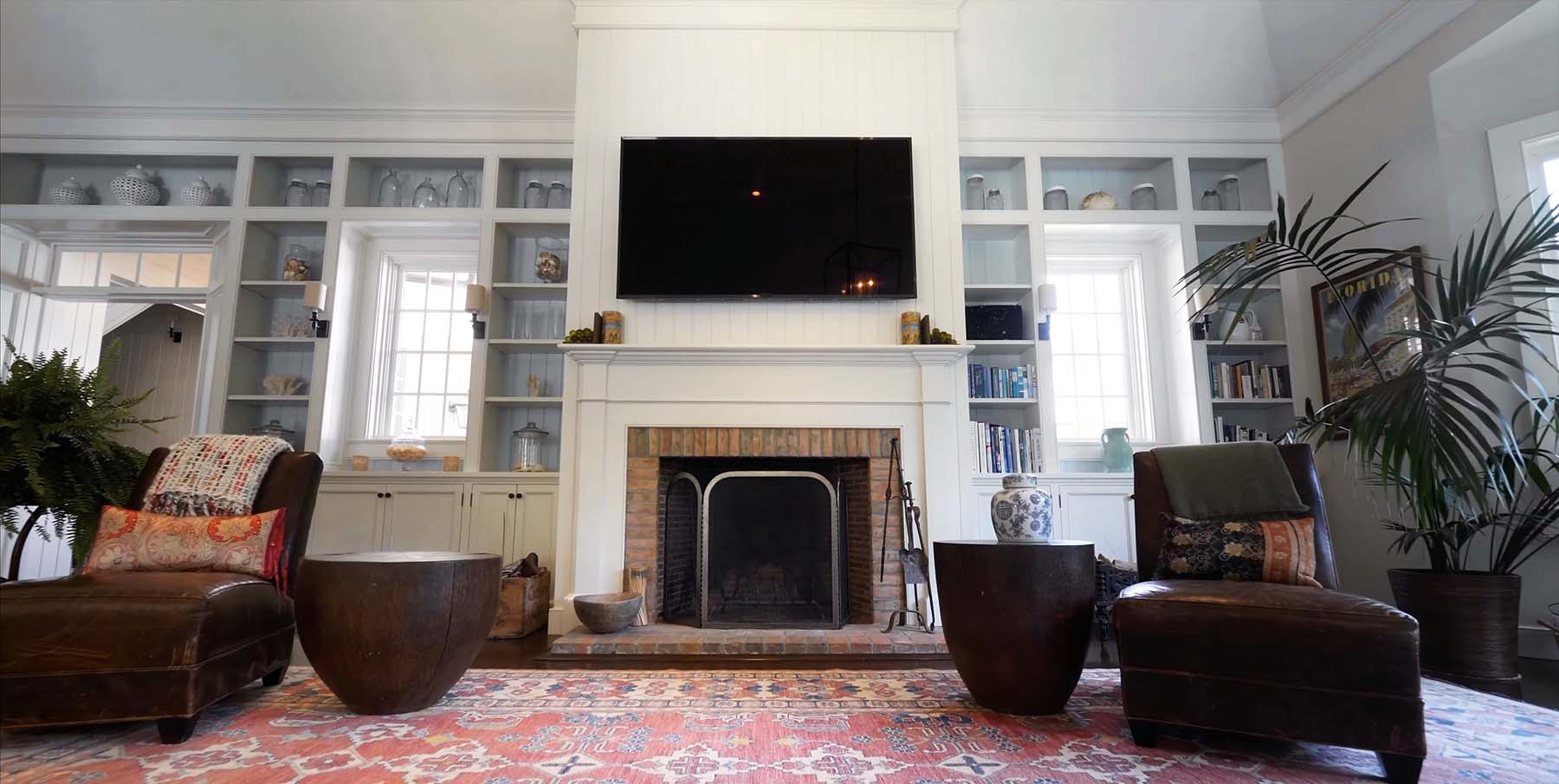 red brick fireplace with wood surround white wall paneling wall mounted TV built ins