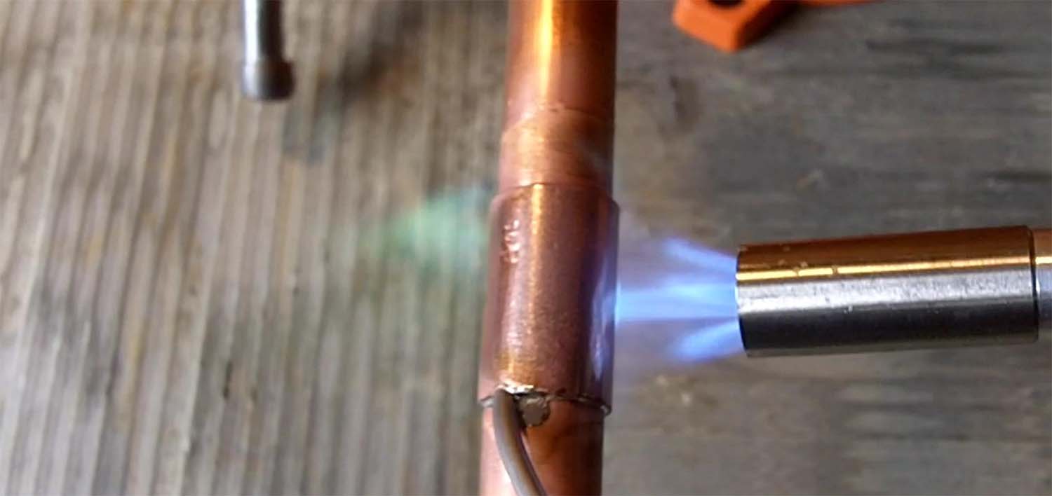 a copper pipe being soldered