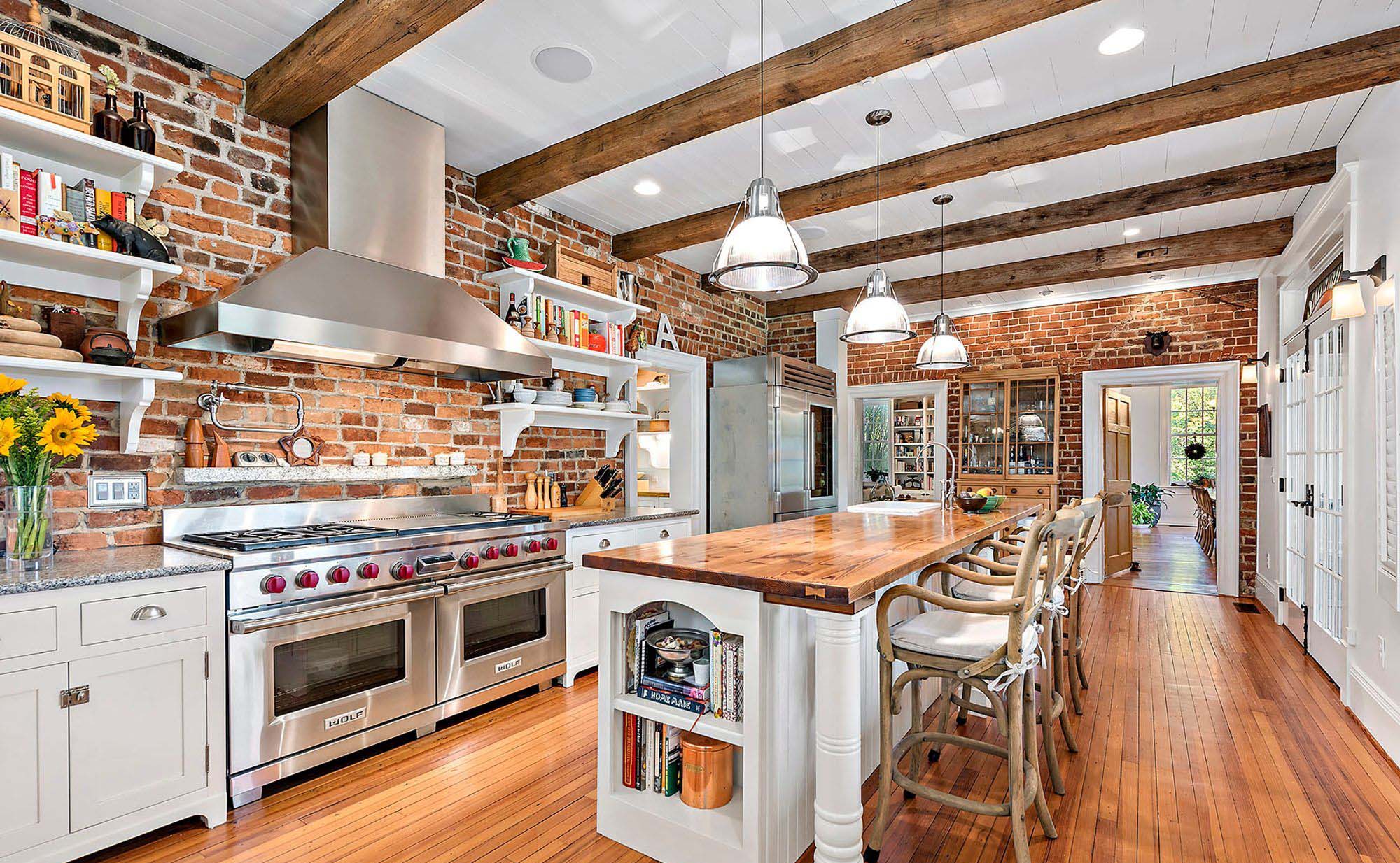 red brick walls in the kitchen with exposed real wood ceiling beams