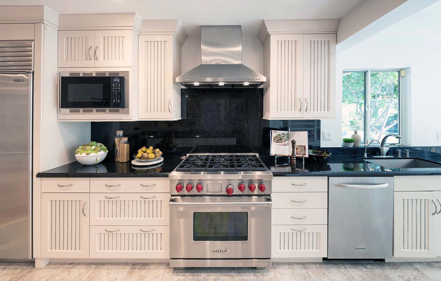 black granite backsplash and countertops with a wolf stove
