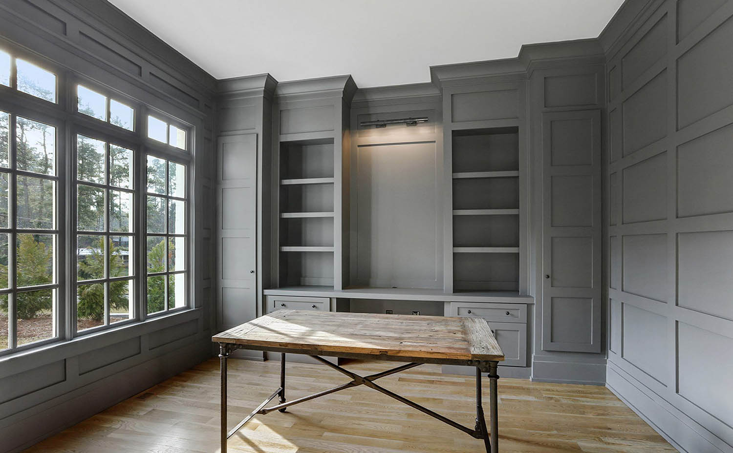 Wood walls painted gray with wall penling and built ins. Square shaker style trim design.