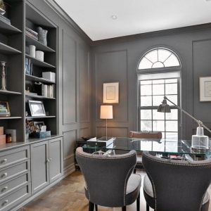 Wood paneling painted gray. Built in cabinets and shelving. Monochromatic design.