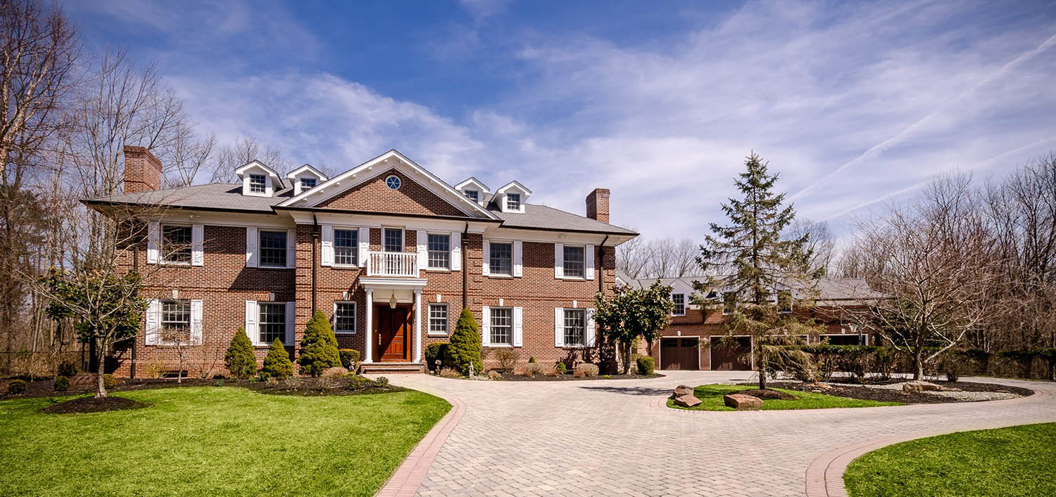 Large Red Brick Home With Dormers And A Gray Shingle Roof