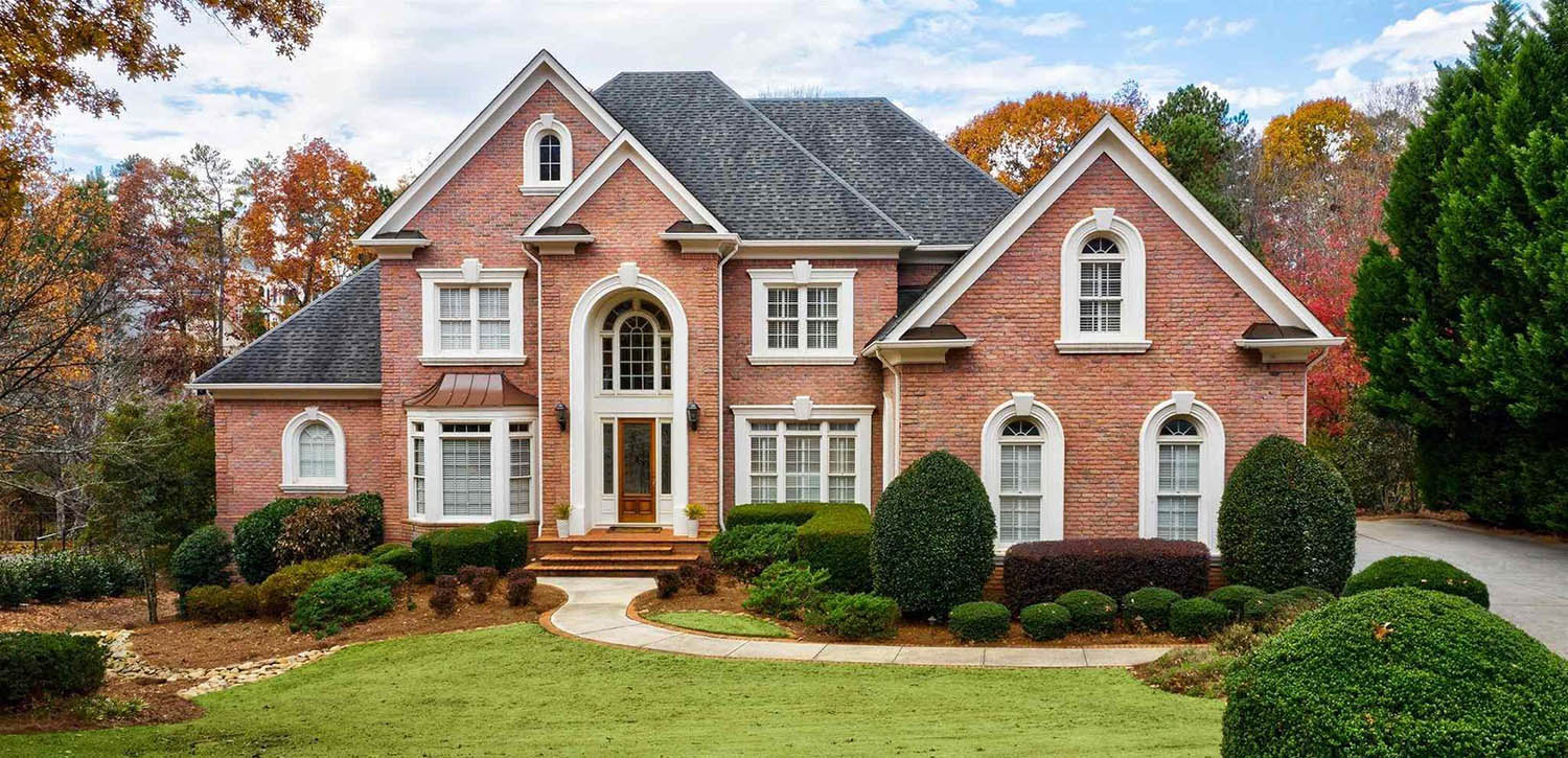 red brick house with cement formed trim and wood front door nice landscaping