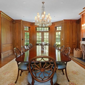 Dining room. All wood walls with custom trim and crown molding. Large dining table.
