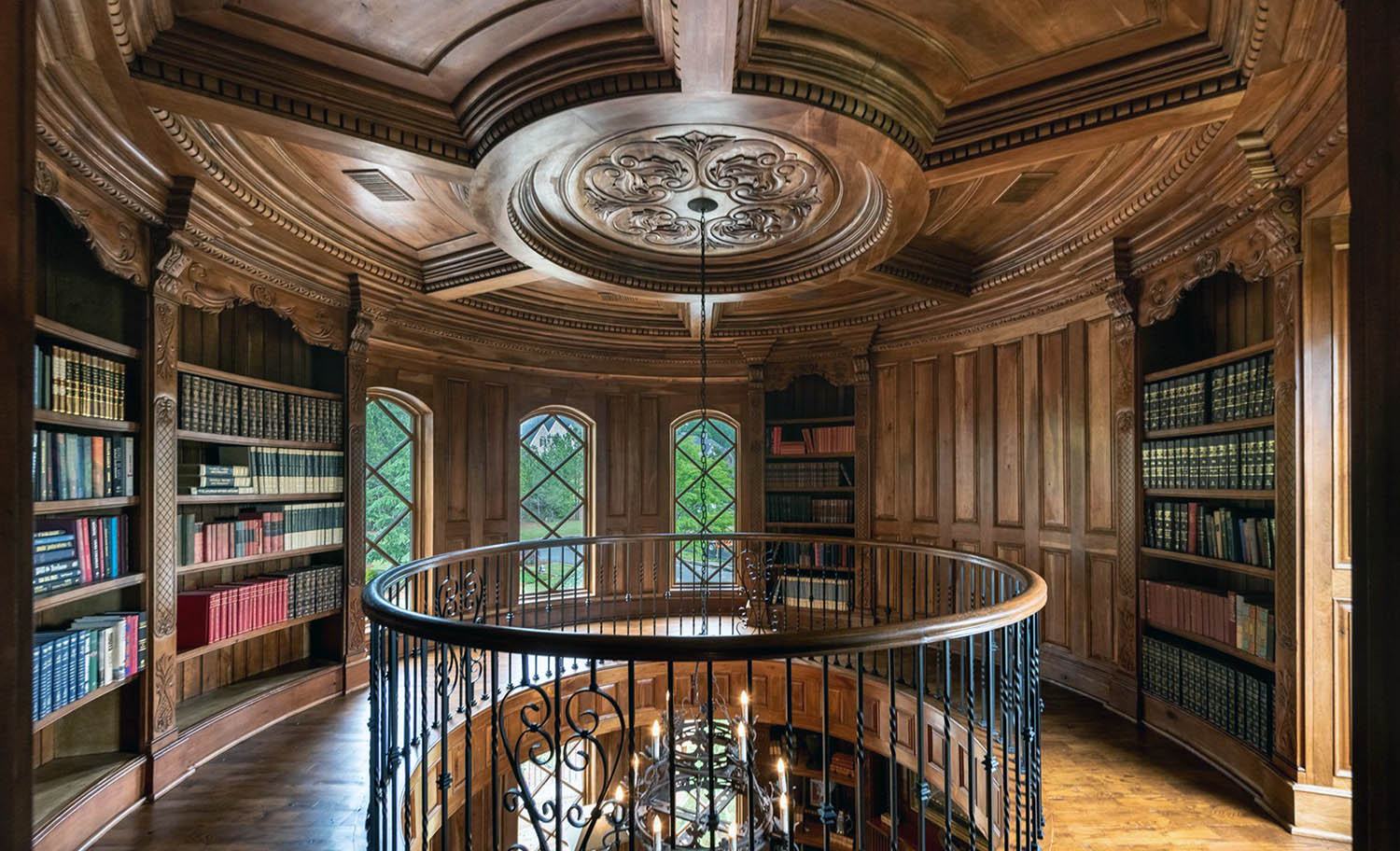 Beautiful round home library with all wood walls and coffred ceiling.