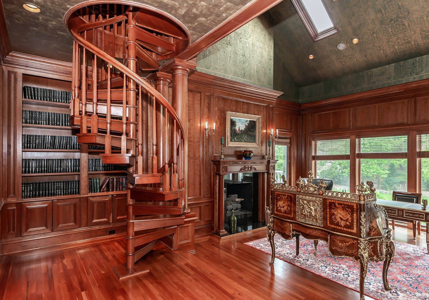 home library / office with all wood walls and matching floors. Reddish brown stain. Spiral staircase.