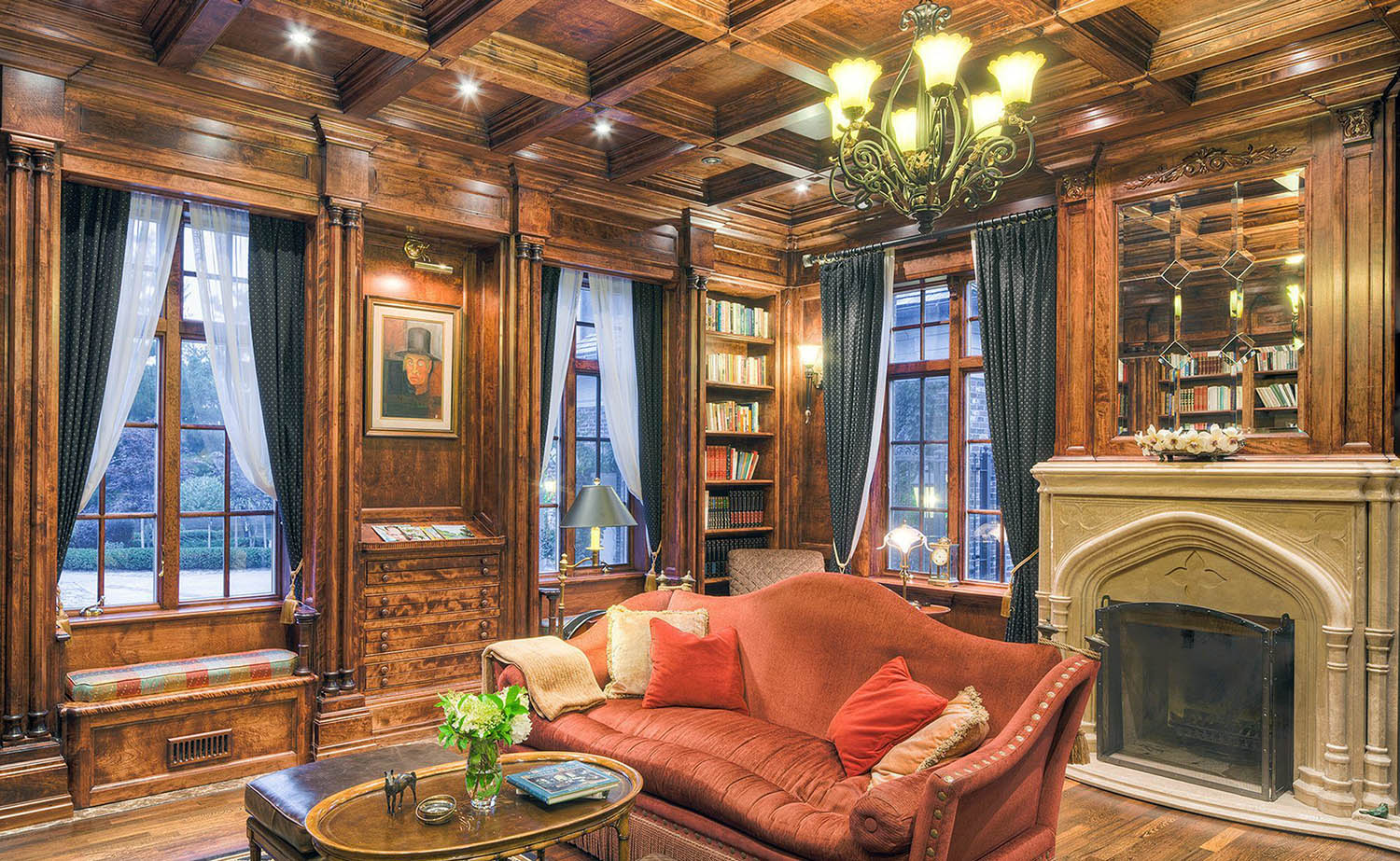 Wood wall paneling with coffered ceiling. Built in shelves and cabinets. Large fireplace surround. Hardwood floors.