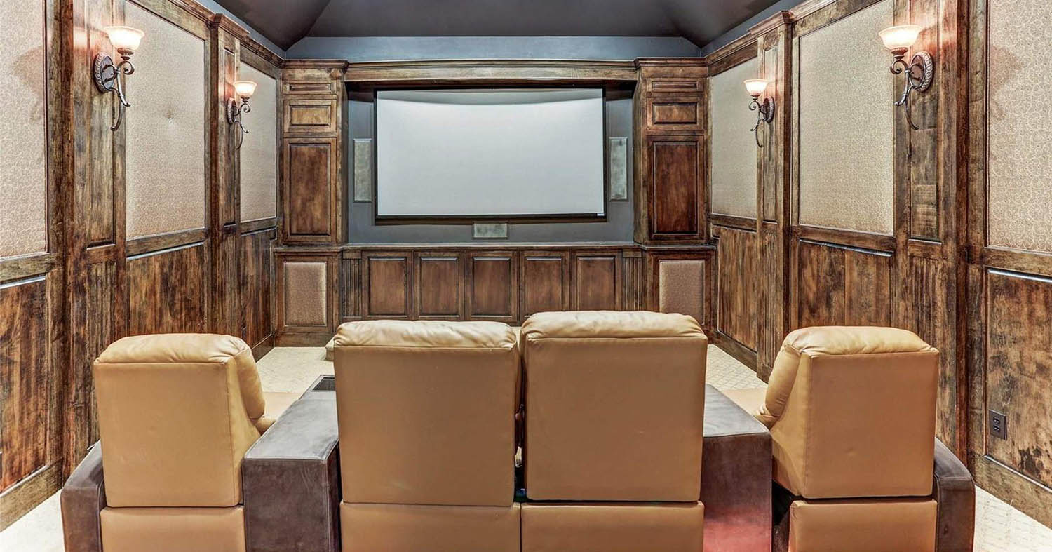 Wooden walls in a home theatre room with leather recliners.