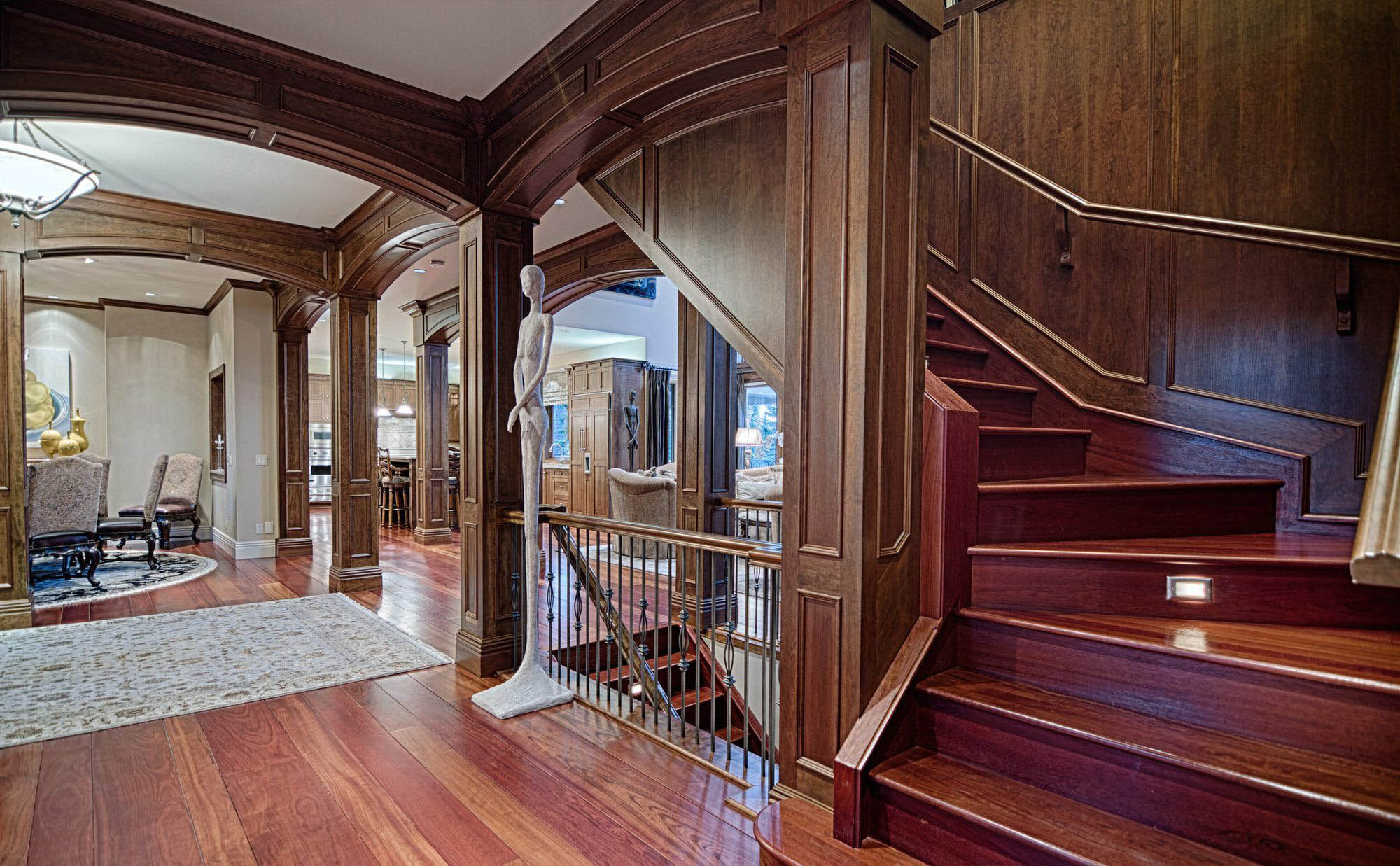 Rich real wood wall paneling with matching trim, stairs and columns.