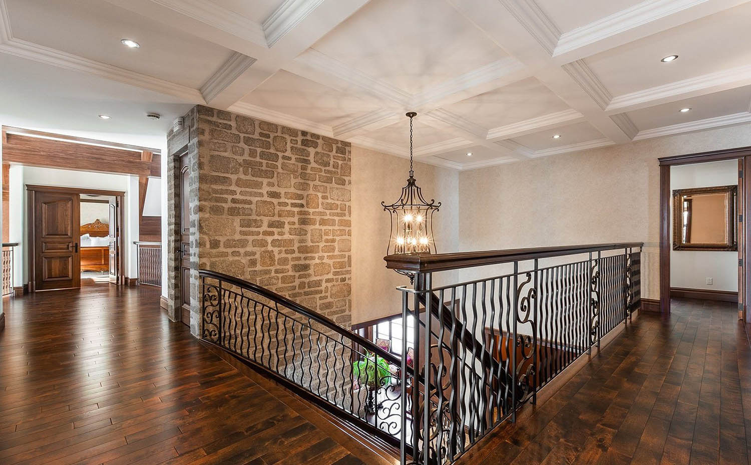 Second floor all white coffered ceiling over the main staircase and hallway with chandelier.