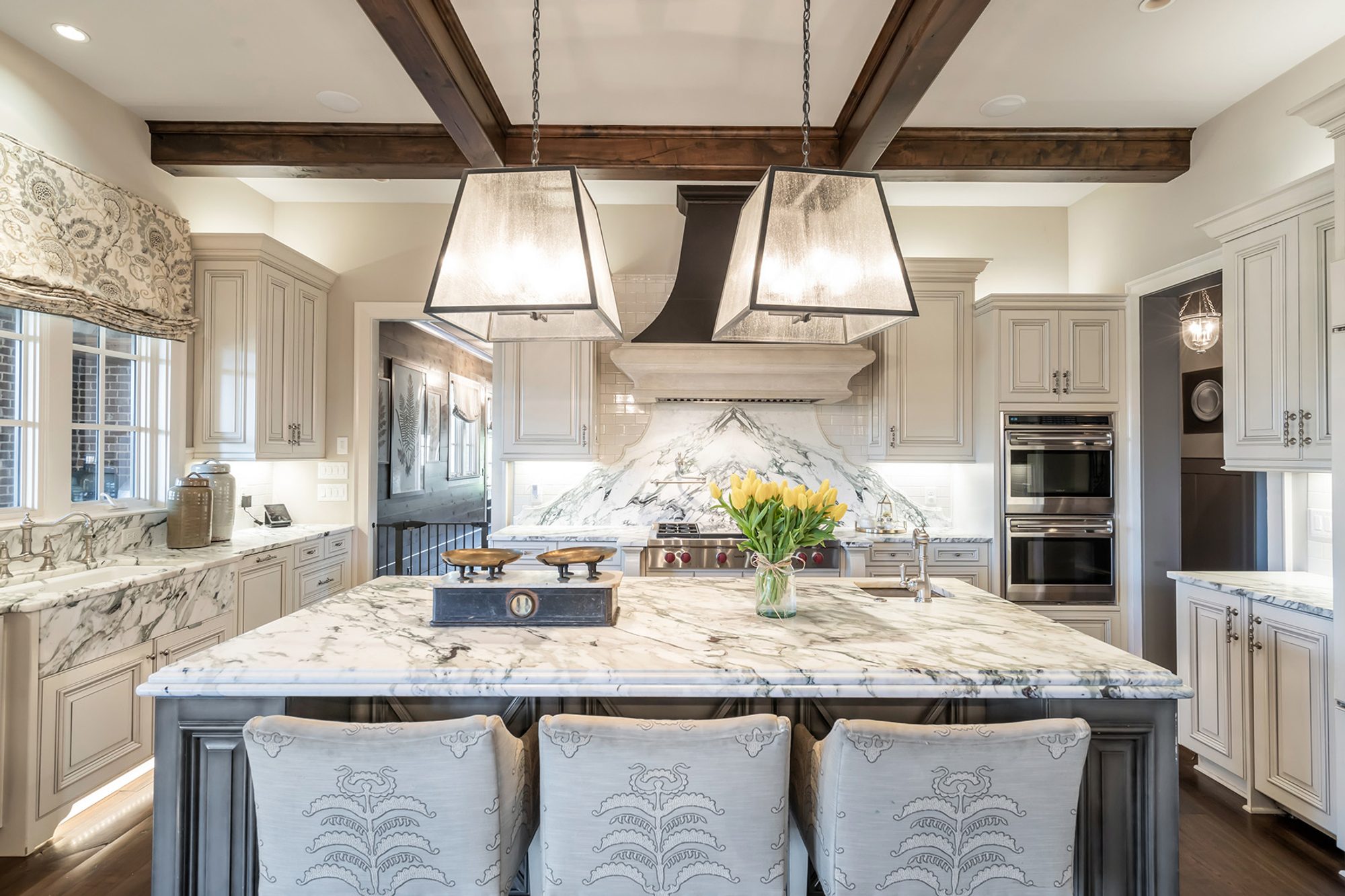 Custom high end kitchen with marble countertops and solid slab backsplash, Dark wood coffered ceiling.