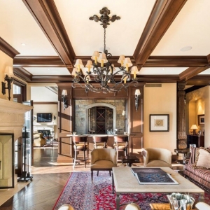 Beautiful living room with brown neutral color palette. Real wood stained coffered ceiling with iron chandelier.