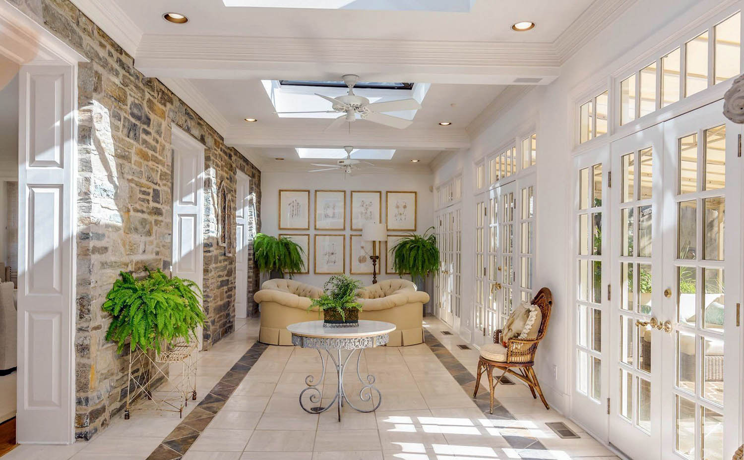 Sunroom coffered ceiling. White beams and coffers. Tile floors with inlay. White walls and ceiling. Stone veneer walls.