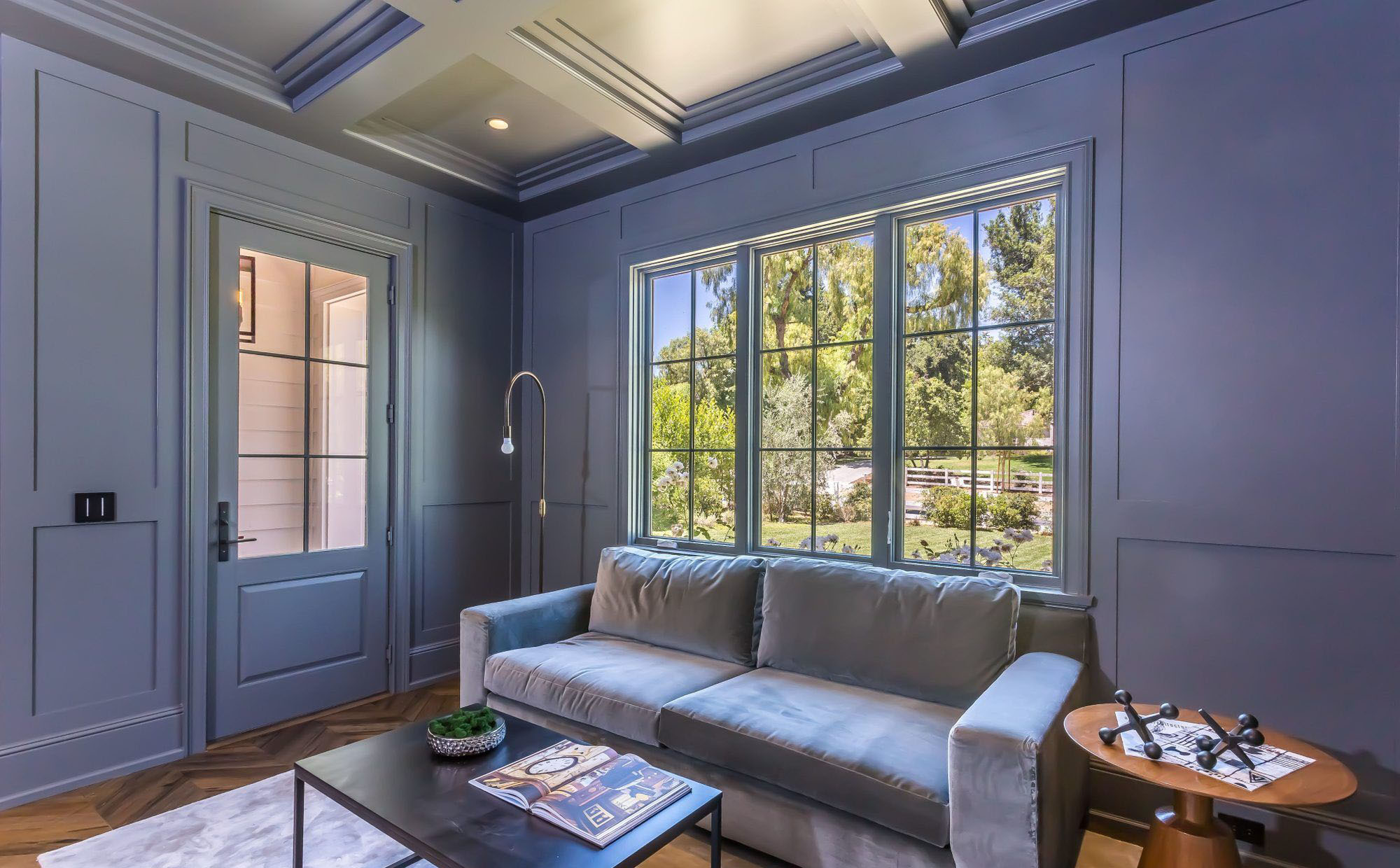 Blue monochromatic sitting room with matching blue coffered ceiling.