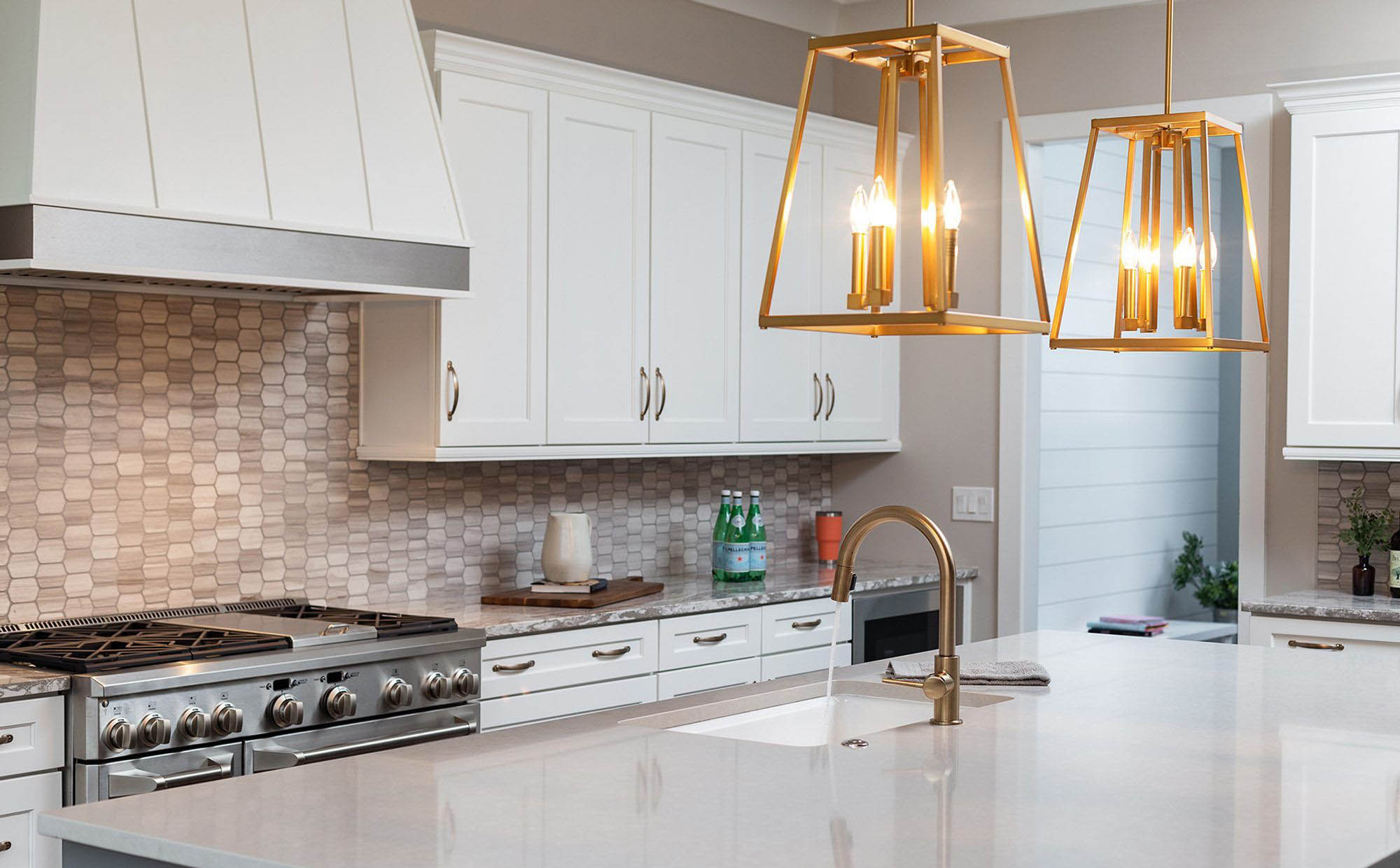 Quartz kitchen countertops with a cream color. Gold metallic finishes. quartz vs granite. 