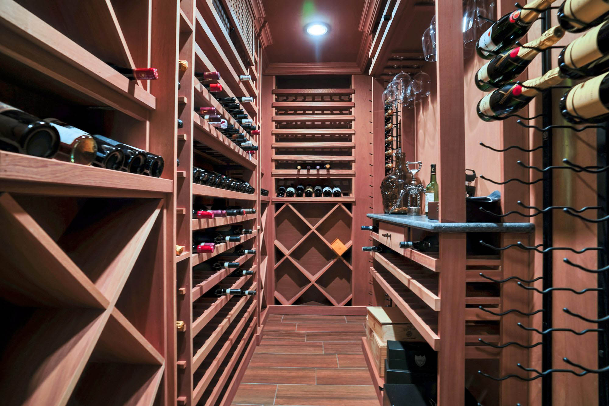 Beautiful wine room with rich wood tile flooring. Matching wood wine storage racks.